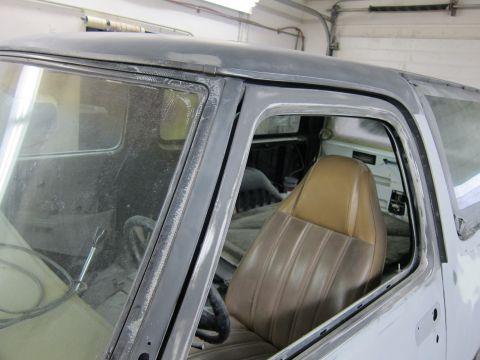 1987 Dodge 1500 - The interior of a truck, possibly from the 1980s, is visible through the open passenger door frame.