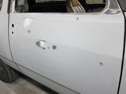 1987 Dodge 1500 - This 1987 Dodge 1500 truck door is undergoing bodywork, showing areas with primer and filler.