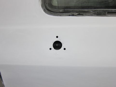 1987 Dodge 1500 - A section of a vehicle's bodywork, possibly a door or fender, shows preparation for mounting hardware.