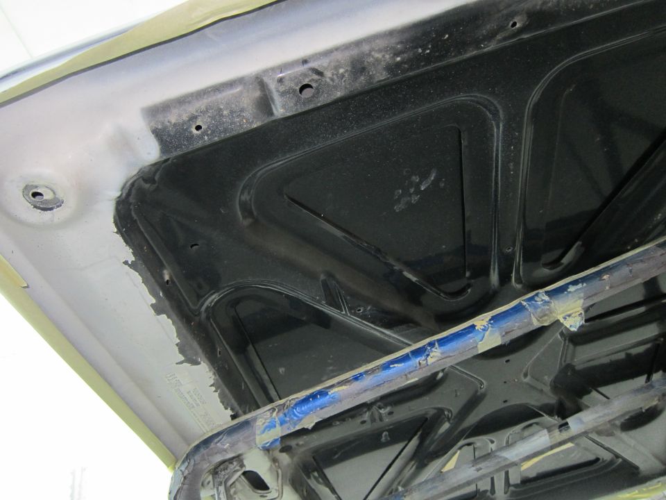 underside of a car hood, showing bracing and insulation material