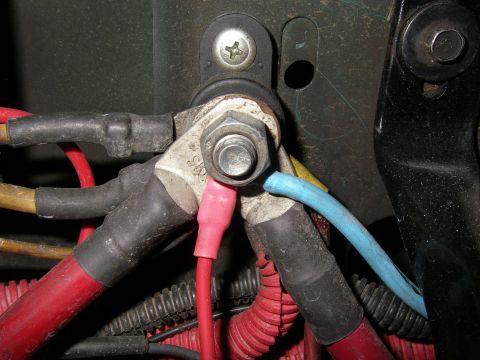 1990 Ford Bronco - Close-up of a starter solenoid or junction stud with multiple red and blue battery cables bolted on.