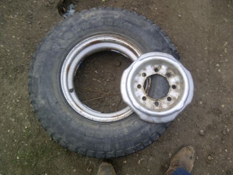 1979 Ford E250 - A tire and wheel are shown on the ground next to a separate wheel rim.
