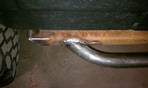 1979 Ford Bronco - A custom step bar is welded onto the frame of a vehicle, with a tire visible in the shot.