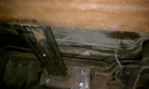 1979 Ford Bronco - The underside of a vehicle reveals its mechanical components and structural elements, showing signs of age and modification.