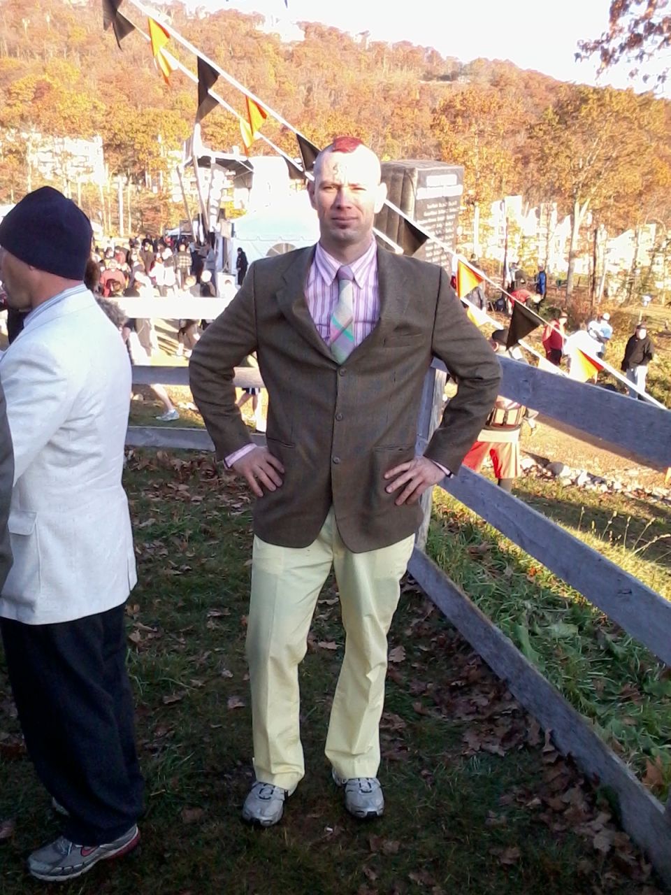 Man in blazer and mohawk posing at an outdoor fall event