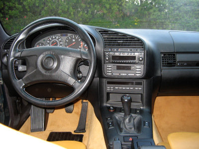 1998 BMW M3 - The dashboard and center console of a BMW are visible, a manual transmission shifter and various controls.