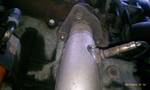 1994 Ford Probe - A close-up view of a catalytic converter and an oxygen sensor on a vehicle's exhaust system. The metal components show signs of heat exposu…