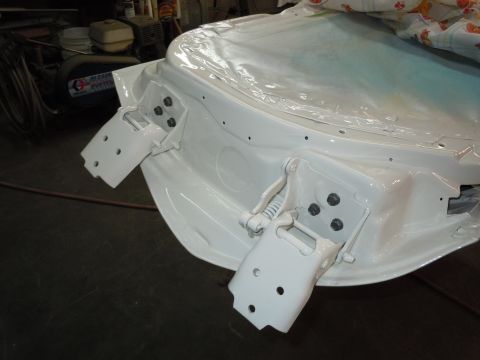 1973 Pontiac Trans Am - Close-up of white car door hinges and frame, covered with plastic sheeting, in a workshop setting.