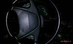 1994 Ford Probe - The interior of a car is dimly lit, focusing on the steering wheel and surrounding dashboard elements.