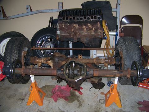 1992 Jeep YJ - Front axle and engine block of a Jeep YJ, disassembled and supported on jack stands.