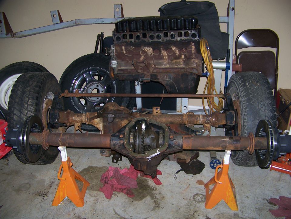 Jeep YJ front axle assembly with engine block, supported by orange jack stands