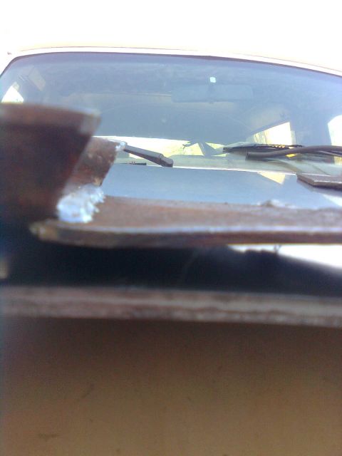 1984 Ford Bronco - Close-up view of windshield wipers and the hood of a vehicle, showing signs of wear.