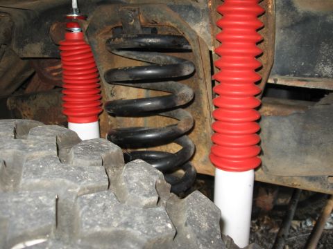 1978 Ford Bronco - Vehicle suspension components including red shock absorbers and a coil spring are visible.
