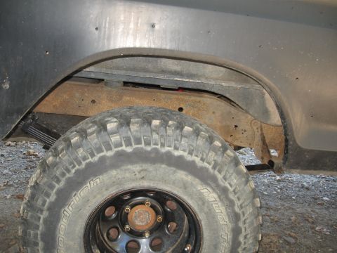 1978 Ford Bronco - The rear suspension and tire are visible, showing off-road modifications and some rust on the frame.