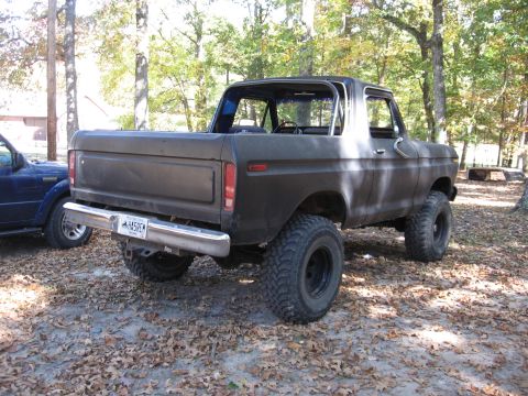 1978 Ford Bronco - A lifted 1978 Ford Bronco with large off-road tires is parked outdoors next to another vehicle.