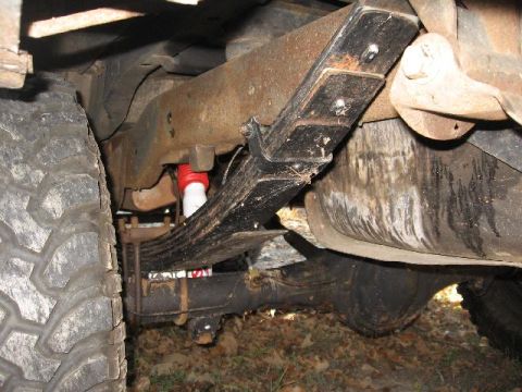 1978 Ford Bronco - Vehicle's rear suspension with leaf springs and a red shock absorber visible.