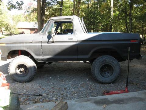 1978 Ford Bronco - This 1978 Ford Bronco is parked outdoors with a jack nearby, suggesting it might be undergoing maintenance or modification.