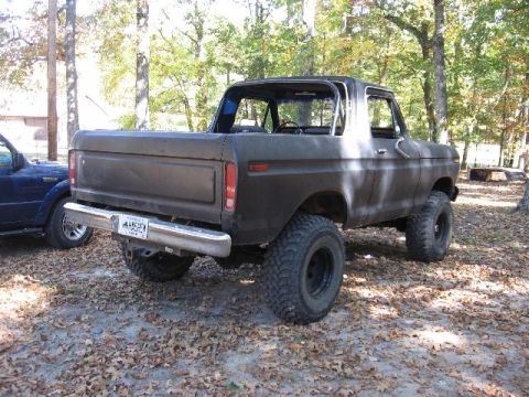 1978 Ford Bronco - This 1978 Ford Bronco features a lifted suspension and large off-road tires, parked beside another vehicle.