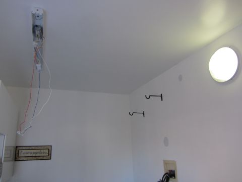 1968 Ford Mustang - A room interior with unfinished ceiling wiring and wall-mounted hooks.