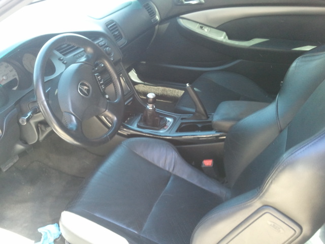 Interior view of a car with black leather seats and a manual shifter