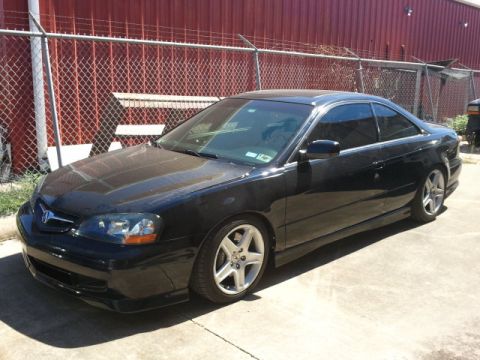 2008 Subaru Legacy - Black Acura CL coupe parked outside a building with a red wall.