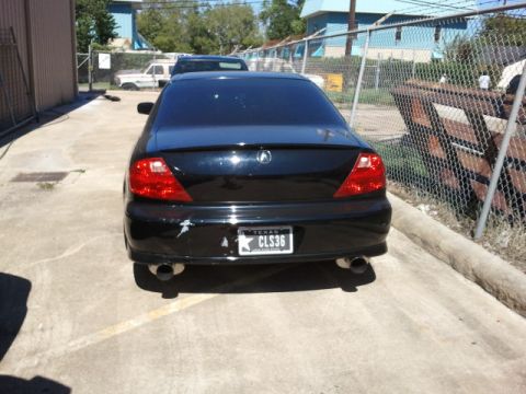 2008 Subaru Legacy - The rear view of a black Acura CL sedan shows dual exhaust pipes and a Texas license plate.