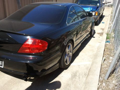 2008 Subaru Legacy - A black coupe is parked alongside a blue pickup truck.