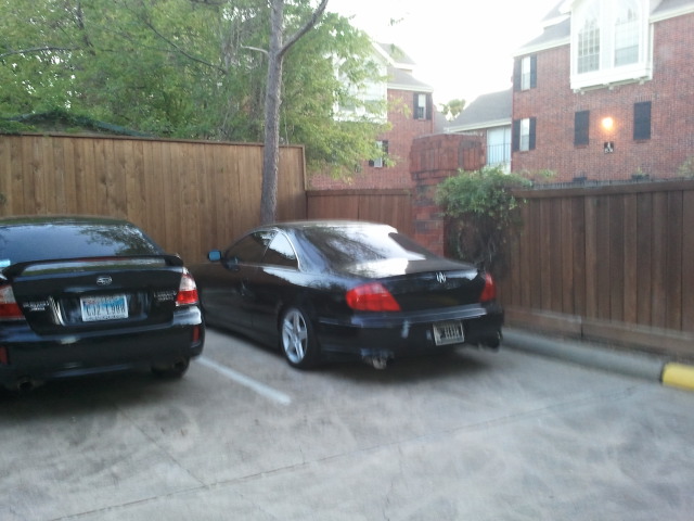 Black Subaru Legacy wagon parked next to a black Acura coupe