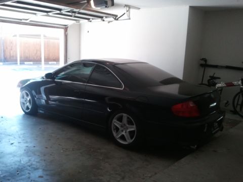 2008 Subaru Legacy - A black coupe sits in a garage, with a bicycle visible in the background.