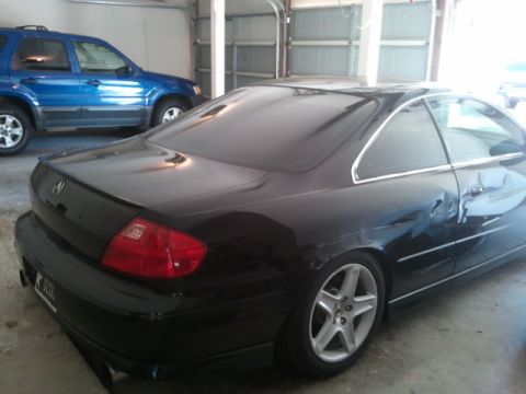 2008 Subaru Legacy - A black coupe is parked in a garage, with a blue SUV visible in the background.