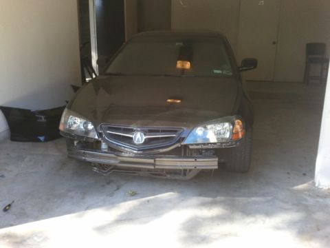 2008 Subaru Legacy - Front view of a dark sedan with its front bumper removed, revealing the underlying structure. The vehicle's grille and headlights are visib…