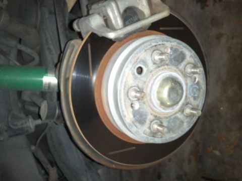 2008 Subaru Legacy - A close-up view of a vehicle's brake system, showing the rotor, caliper, and part of the suspension.