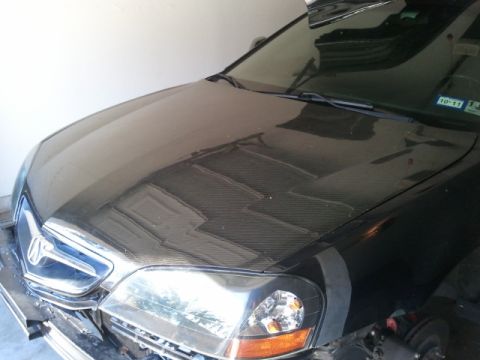 2008 Subaru Legacy - Front view of a car's hood, a carbon fiber wrap and a chrome grille. The headlights are visible.