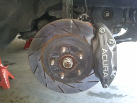 2008 Subaru Legacy - Close-up of an Acura brake caliper and rotor assembly, indicating a specific vehicle part.