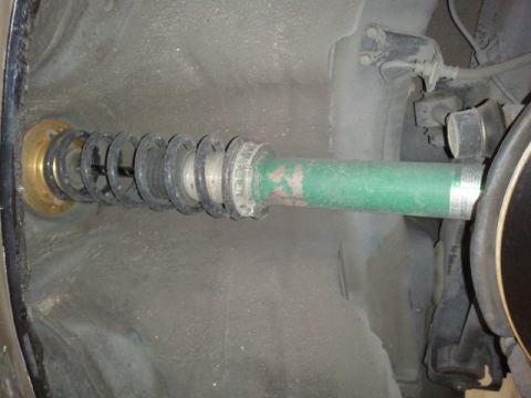 2008 Subaru Legacy - Close-up view of a green suspension strut and coilover assembly, likely from the rear of a vehicle.
