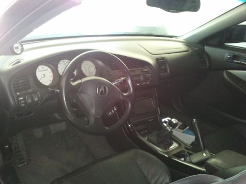 2008 Subaru Legacy - The interior of a car is shown, a steering wheel with an Acura logo and white-faced gauges on the dashboard.