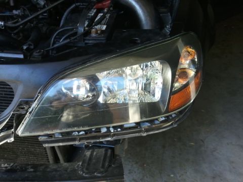 2008 Subaru Legacy - Close-up of a 2005 Honda Accord's headlight and part of the engine bay.