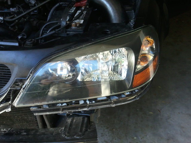 Front headlight assembly of a 2005 Honda Accord. Engine bay visible above