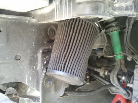2008 Subaru Legacy - Close-up view of an engine air filter and suspension components, including a green shock absorber.