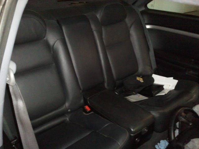 back seat of a car with black leather seats and a center console