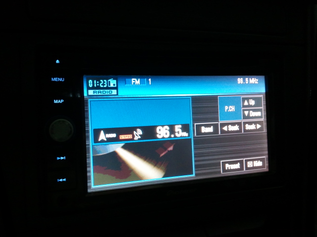 Car radio display showing FM station 96.5 MHz and time 01:23