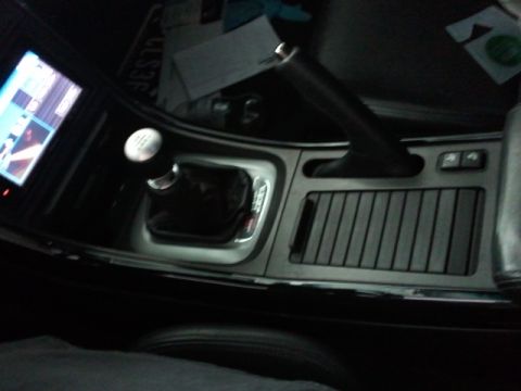 2008 Subaru Legacy - The center console of a car features a manual gear shifter and a handbrake lever.
