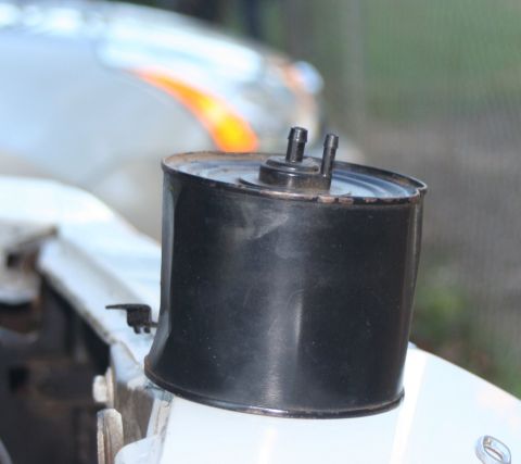 1976 Ford Ranchero - A close-up view of a black vacuum canister with two small hose connections.
