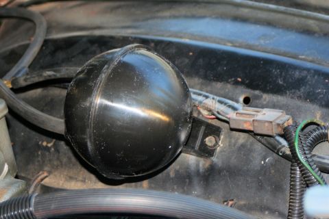 1976 Ford Ranchero - A black spherical vacuum reservoir is mounted in the engine bay with associated wiring and hoses.