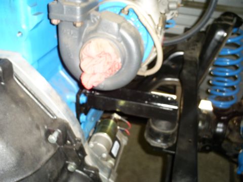 1992 Ford Bronco - Close-up view of a turbocharger and blue suspension spring within an engine bay.