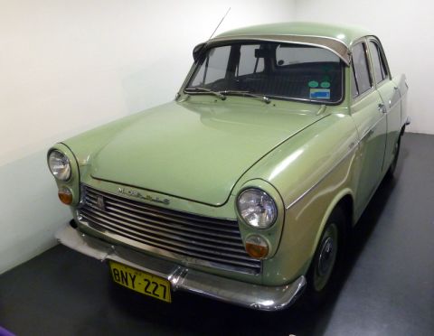 1969 MINI Cooper - A light green Morris sedan is shown from a 3/4 front view, a prominent chrome grille and a yellow license plate.