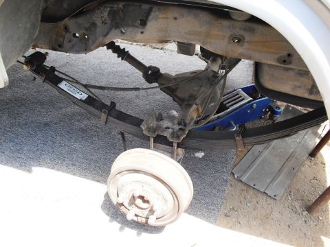 1986 Ford Bronco - Underside view of a vehicle's rear suspension system, showing leaf springs and a differential.