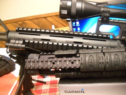 2012 Ford Mustang - This image shows a close-up view of an assault rifle with tactical accessories, including a scope and rail system.