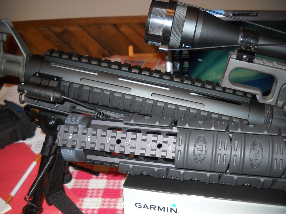 Assault rifle with scope and bipod, close-up view of tactical rails and accessories