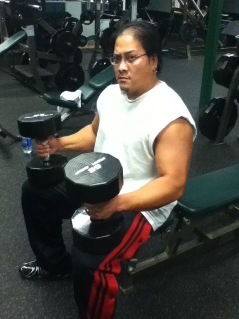 2006 Ford E350 - A man is seen working out with dumbbells in a gym setting, surrounded by weightlifting equipment.